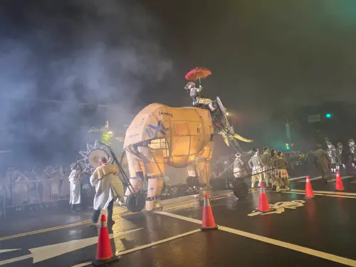 ▲《大象來了》終場遊行在風雨中展開，機械大象無畏雨勢上街與民眾見面。（圖／記者周淑萍攝）