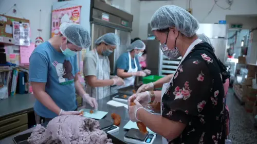 ▲聲暉協進會的心智障礙學員與志工媽媽製作鳳梨酥等產品，應付接下來的秋節訂單出貨。（圖／記者王郁勳攝）