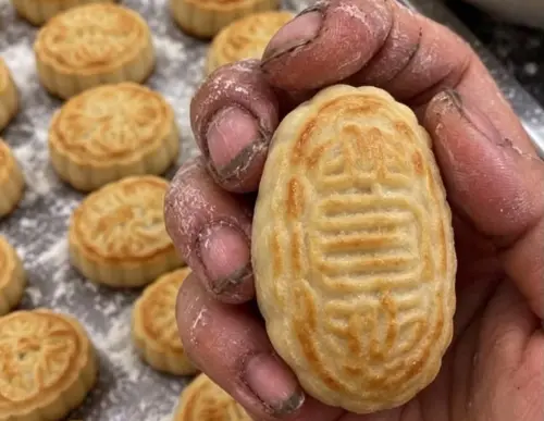 ▲有網友實測將AI生成的髒指甲月餅圖傳給自家母親，畫面中可見一雙指甲縫藏滿黑色垢物的手正徒手抓著月餅，看起來十分驚悚。（圖／翻攝Threads）