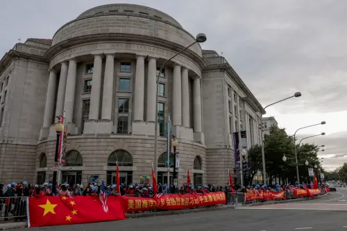 ▲習近平入住的酒店外，街道對面也有高舉中國國旗的歡迎民眾。（圖／路透／達志影像）