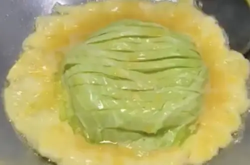 ▲泰國廚娘將高麗菜頂端切刻花後放油鍋，並倒入大量蛋液煎香，沾泰式辣醬相當開胃。（圖／翻攝Facebook／แม่ค้า แม่ครัวChannel）