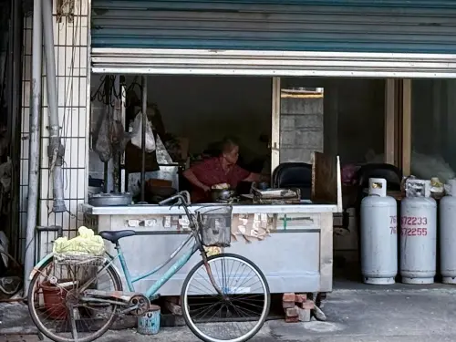 ▲高雄前鎮爆紅的碗粿小吃攤內，目前僅剩80歲老闆娘獨自坐在空店面內。（圖／記者葉盛耀攝）
