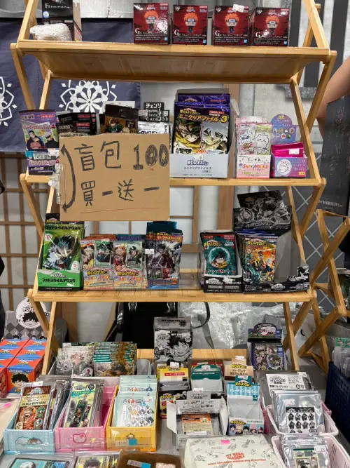 ▲《漫漫玩第十二回合》攤位可見《我的英雄學院》等人氣作品周邊，部分盲包商品祭出100元買一送一。（圖／記者林若瑋攝）