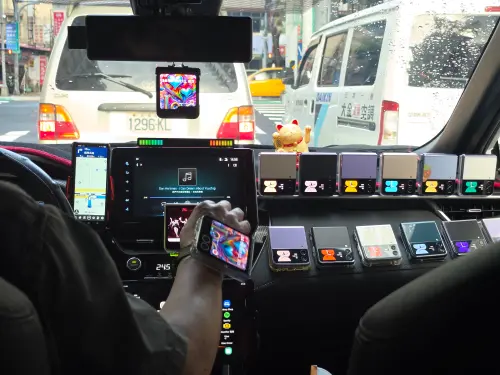 ▲王先生將多支Galaxy Z Flip整齊擺在車內，還特別準備試玩機讓乘客體驗，外國乘客看到時常驚訝要求拍照。（圖／民眾提供）