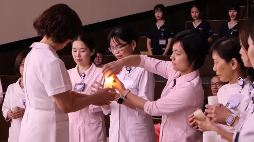▲傳光儀式中，由護理系系主任郭素娥傳光予教師群。（圖／中山大學提供）