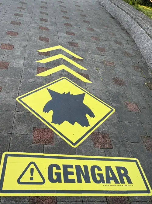 ▲地面出現耿鬼剪影與黃色「GENGAR」警示標誌。（圖／記者林若瑋攝）