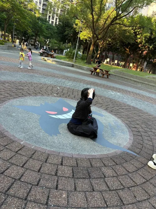 ▲寶可夢30週年「Pokégenic」打卡活動將耿鬼融入公園地面，民眾可以直接坐在耿鬼圖案上，拍出與寶可夢互動的趣味照片。（圖／記者林若瑋攝）
