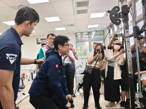▲ 高雄市長陳其邁參觀路竹運動中心館內設施與規劃，親身體驗健身器材，現場來賓也一起為陳其邁加油。（圖／高市府提供）
