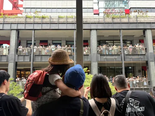 ▲寶可夢30週年，不少家長抱著孩子一起等待寶可夢登場，就算沒搶到限定商品，也能在信義區看遊行、跑打卡點。（圖／記者林若瑋攝）