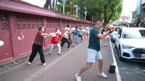 ▲長輩在赤崁樓前跟著教練打拳擊，前後測數據顯示全然專注的長者人數增加3.5倍。（圖／記者王郁勳攝）