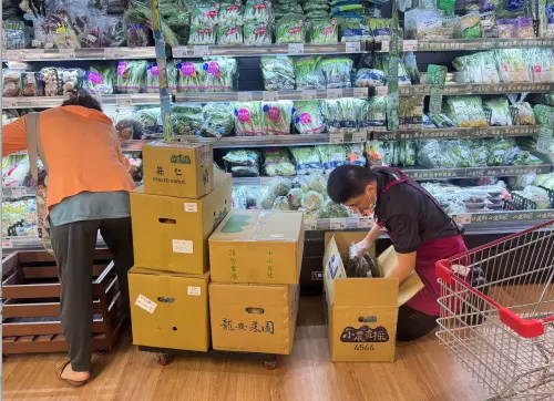 ▲面對現場需求，店員也持續整理貨架、補上商品，一箱箱蔬菜陸續推到冷藏櫃前，維持架上供應。（圖／記者鍾怡婷攝）