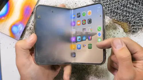 ▲YouTuber將大量沙塵灑在iPhone Duo螢幕及轉軸附近，測試異物對摺疊機構的影響，結果手機無法完全闔上。（圖／翻攝JerryRigEverything YouTube）