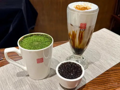 ▲左起：「海苔焙茶花生拿鐵（熱飲）」小杯中南區135元／北桃竹140元、中杯中南區240元／北桃竹250元。「冰琥珀拿鐵」小杯中南區125元／北桃竹130元、中杯中南區220元／北桃竹230元。（圖／記者蕭涵云攝）